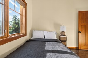 Une chambre à coucher avec un lit, une table de chevet, une lampe et une armoire.