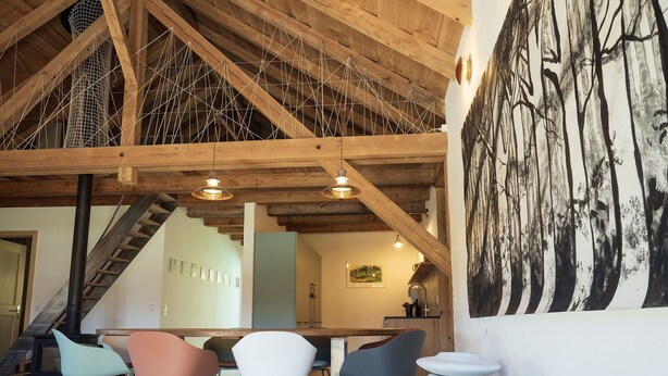 A modern interior with a wooden ceiling, a staircase, and a dining area with chairs. - Appartements - N°5 et N°5B by Interhome (Les Genevez)