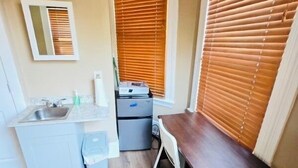 A compact bathroom with a sink, mirror, and wooden vanity. - Ringgold (Providence)