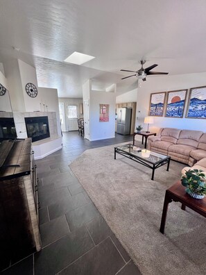 A living room with a fireplace, a ceiling fan, a sofa, and a coffee table. - Spacious 3Bed/2Ba Prescott Home with Great Views! (Prescott)