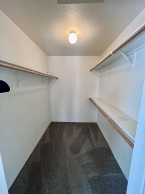 A small, empty walk-in closet with a light fixture on the ceiling and wooden shelves. - Spacious 3Bed/2Ba Prescott Home with Great Views! (Prescott)