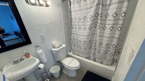 Ein Badezimmer mit Waschbecken, Toilette, Badewanne und Duschvorhang.