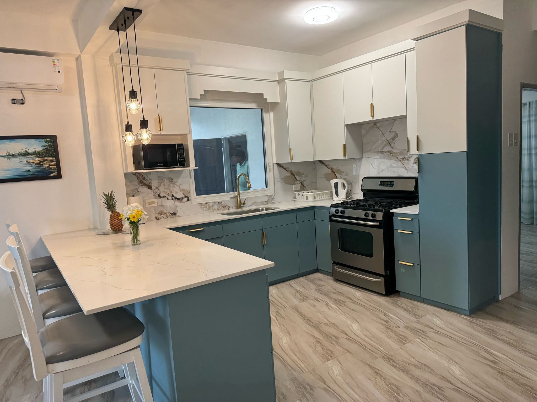 A modern kitchen with a central island, built-in appliances, and a view to the outside.