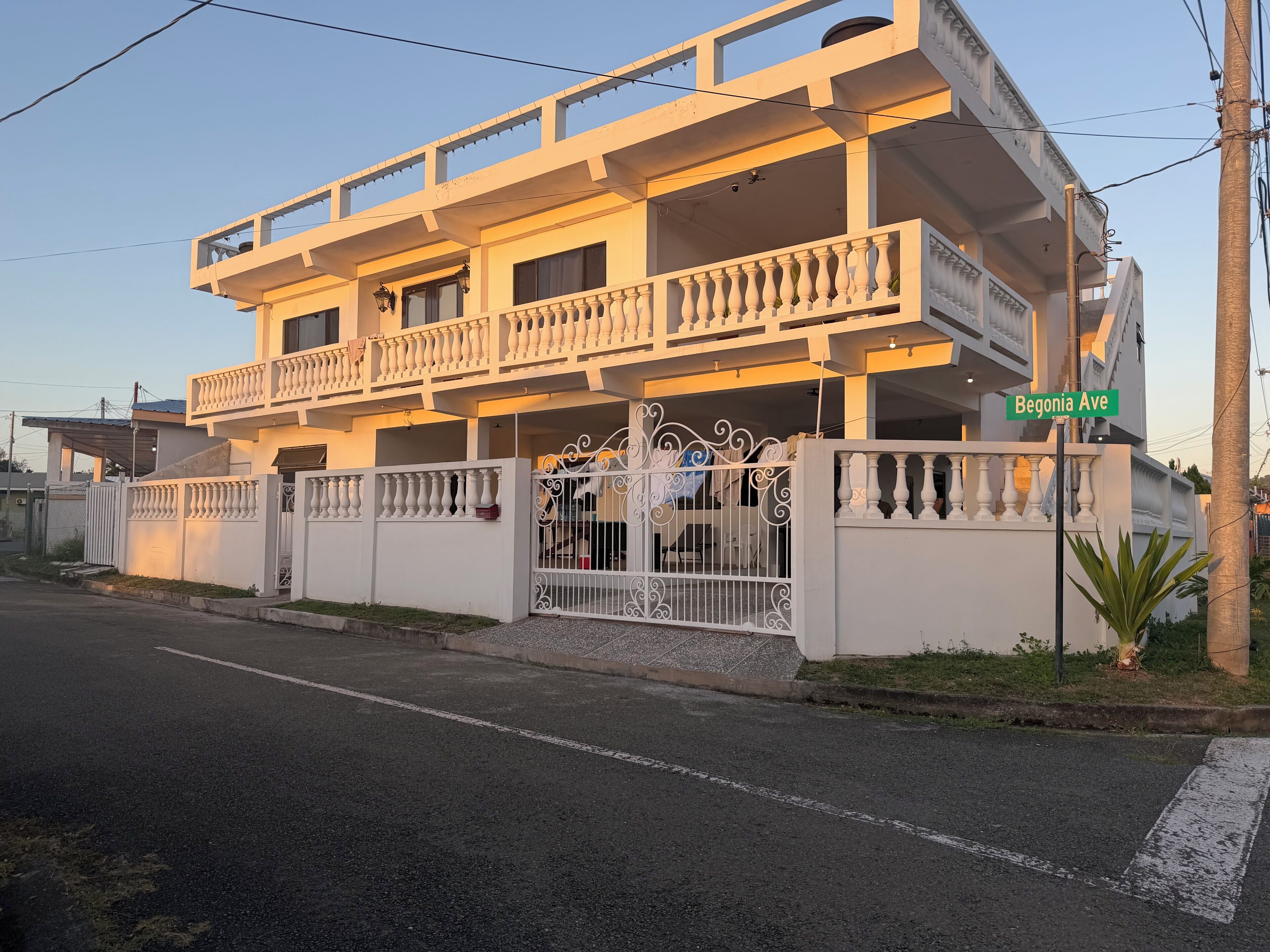 A multi-story building with balconies, a gated entrance, and a street sign indicating 'Begonia Ave.'