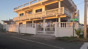 A multi-story building with balconies, a gated entrance, and a street sign indicating 'Begonia Ave.'