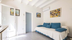 A room with a bed, a door, and two framed paintings on the wall. - Le Patio de la Mer – Comfortable one-bedroom flat with terrace in Valras-Plage (Valras-Plage)