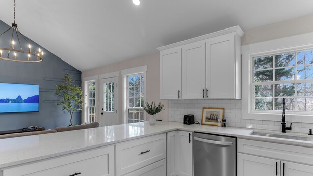 A modern kitchen with white cabinetry, a stainless steel dishwasher, and a large island with a built-in sink. - Sleep 9 Boiling Springs SC w/2 kings, Pool Table (Boiling Springs)