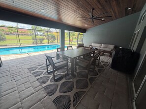 Eine Terrasss mit Pool, Tisch, Stühlen und einer Sitzecke.