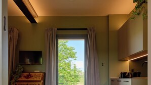 Eine moderne Küche mit großem Fenster, einem Flachbildfernseher und einem Fischgrätparkett.