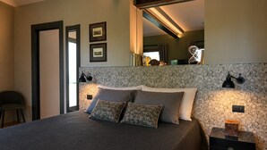 Ein Schlafzimmer mit einem Bett, zwei Wandlampen, einem Spiegel und einem Nachttisch.