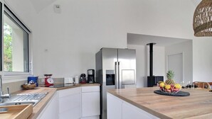Una cucina moderna con un'ampia finestra, elettrodomestici in acciaio inossidabile e un piano di lavoro in legno.