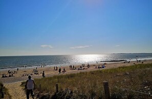 A beach with people, a clear sky, and the ocean. - L'O de Rose - DAMGAN (DAMGAN)