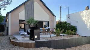 Una casa moderna con un patio, una sala da pranzo e un grande vaso nero.