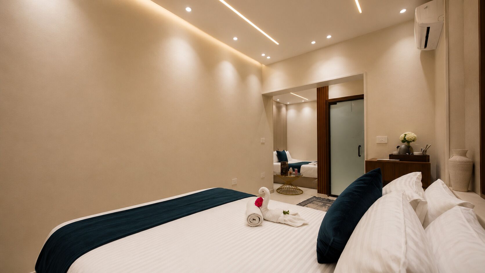 Une chambre d’hôtel comprenant un lit, une table de chevet, un appareil de climatisation et un miroir.