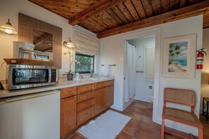 A kitchen with wooden cabinets, a microwave, and a sink. - On the Beach…Retreat on the Sand—2 Units upstairs and downstairs, Sleeps 6 (Indian Rocks Beach)