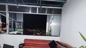 Ein modernes Wohnzimmer mit einer Couch, einem kleinen Tisch und einer Zimmerpflanze.