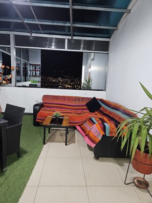 Ein modernes Wohnzimmer mit einer Couch, einem kleinen Tisch und einer Zimmerpflanze.