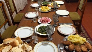 A dining table set for a meal with various dishes, glasses, and bread.