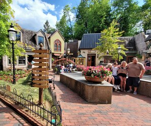 A public square with a directional signpost, a fountain, and various shops. - 1-bedroom resort in Gatlinburg Town Square, Tennessee with AC and fitness room (Gatlinburg)