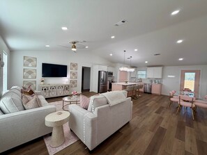 A spacious living area with a sofa, coffee table, and a TV mounted on the wall. - Girl's Night Out - WinStar Bachelorette - King Bed (Love County)