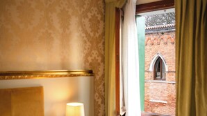 A hotel room with a bed, a nightstand with a lamp, and a window with curtains. - Room-hotel Walter Venezia (Venice)