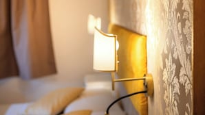 A hotel room with a bed, a nightstand, a lamp, and a patterned wall. - Room-hotel Walter Venezia (Venice)