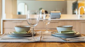A dining table with two plates, a glass, and a fork. - Nest Collection El Golf (Las Condes)