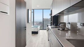 A modern kitchen with a large window, a bed, and a city view. - Deluxe E11EVEN Suite with Elite Amenities (Miami)