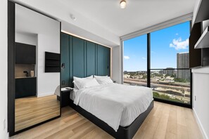 A modern bedroom with a large bed, a built-in wardrobe, and a city view. - 29th Floor E11EVEN Residences Suite Rooftop Pool (Miami)