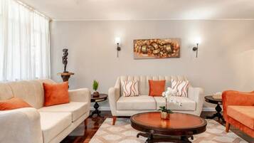 A living room with two sofas, a coffee table, and a painting on the wall.