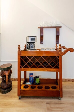 A wooden coffee cart with a coffee maker and a shelf, placed on a wooden floor. - Spacious 5BR for Groups. Rooftop Terrace. Near Malecón & Airport (San Miguel)
