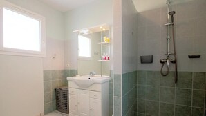 A bathroom with a sink, mirror, and shower. - Le Pin Franc - VALEYRAC (VALEYRAC)