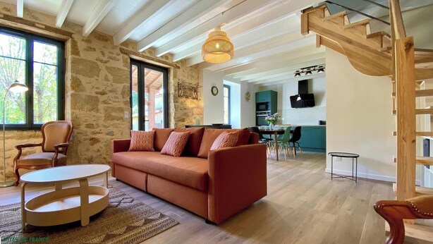 Ein Wohnzimmer mit einer Couch, einem Couchtisch und einem Essbereich mit Stühlen.