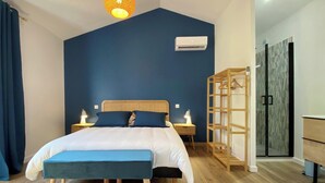 Ein Schlafzimmer mit einem Bett, Nachttischen, einem Kleiderschrank und einer Klimaanlage.