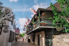 A street with buildings, flags, and a sign for a seafood restaurant. - Stay Downtown St. Augustine 3BR and Parking (St. Augustine)