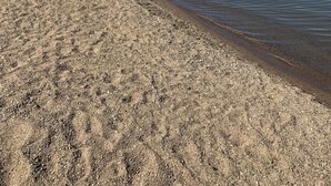 A beach with a clear sky and calm water.
