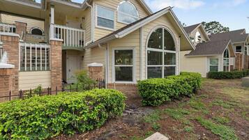 A two-story house with a front porch, a garage, and a well-maintained garden.