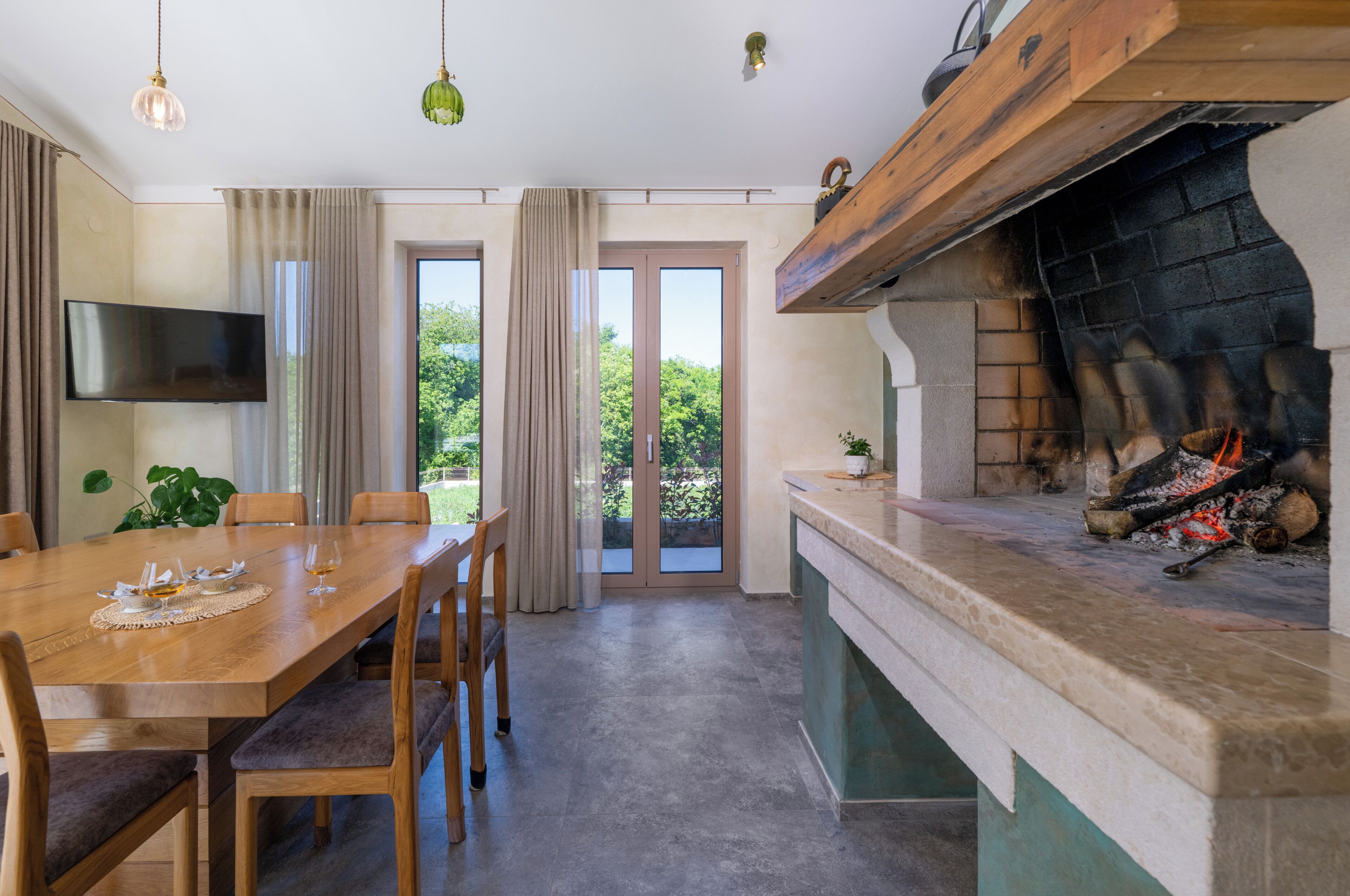 Een eetgedeelte met een houten tafel, stoelen en een open haard.