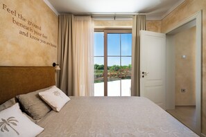 A bedroom with a bed, a wall with a motivational quote, a view through a glass door, and a door leading to another room. - Villa Da Ella (Istria - Krnica) (Krnica)