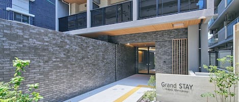 Un edificio moderno con un cartel que dice 'Grand STAY Hakata Nishinakasu'.