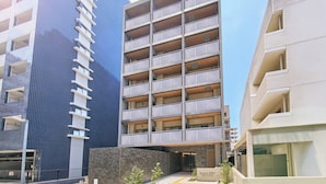 A multi-story building with balconies, a parking garage, and a sign reading 'Grand Stay.' - Grand STAY Hakata Nishinakasu (Fukuoka)