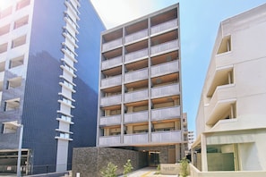 A multi-story building with balconies, a parking garage, and a sign reading 'Grand Stay.' - Grand STAY Hakata Nishinakasu (Fukuoka)