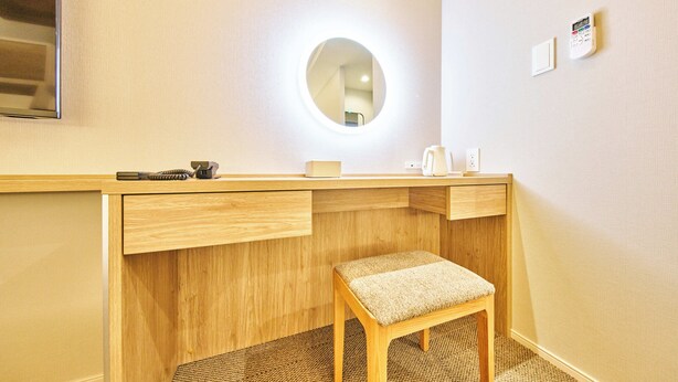 A hotel room with a wooden desk, a round mirror, a small stool, and a wall-mounted thermostat. - Grand STAY Hakata Nishinakasu (Fukuoka)