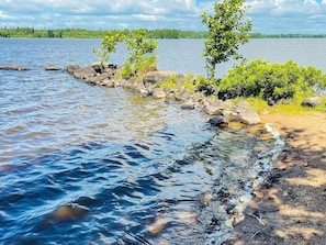 A calm lake with clear water, surrounded by rocks and greenery. - 9 Person Holiday Home in Almhult (Almhult)