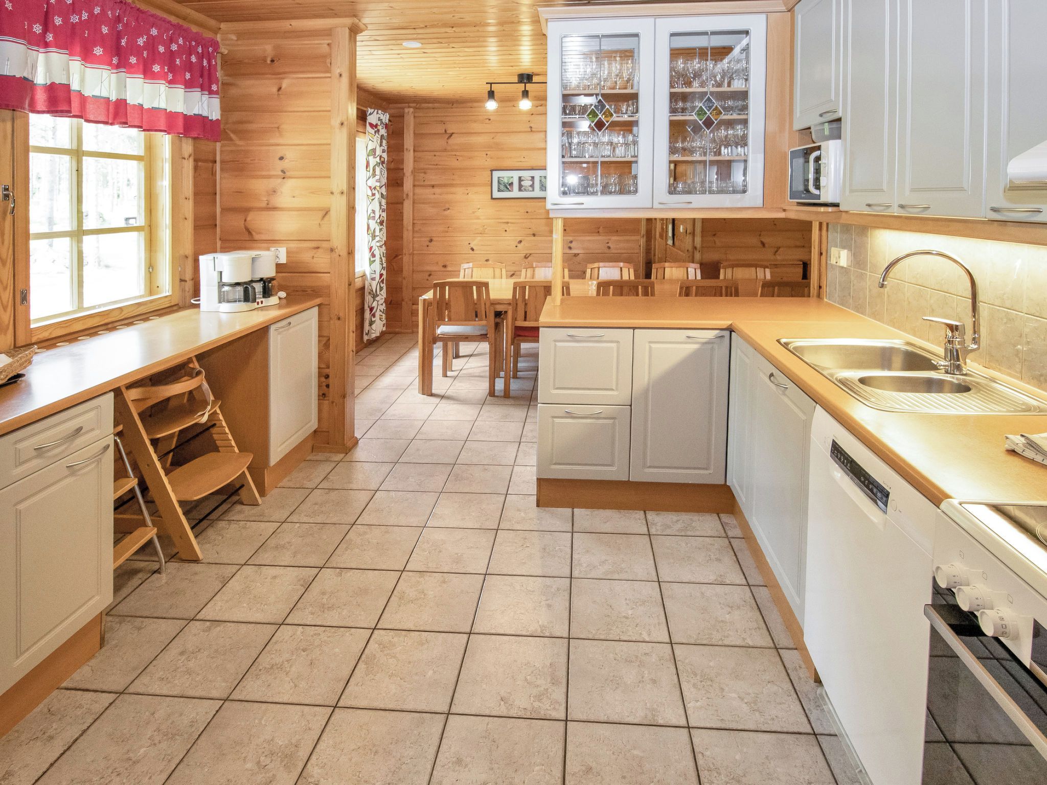 A kitchen with wooden cabinets, a sink, and a dishwasher.