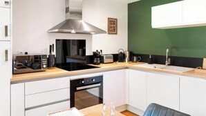 Eine moderne Küche mit Edelstahl-Dunstabzugshaube, Backofen und Mikrowelle.