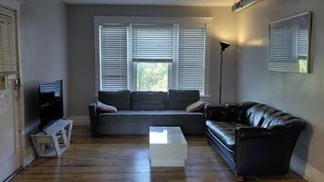 A living room with a sectional sofa, a coffee table, and a floor lamp.