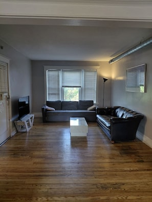A living room with a sectional sofa, a coffee table, and a floor lamp.