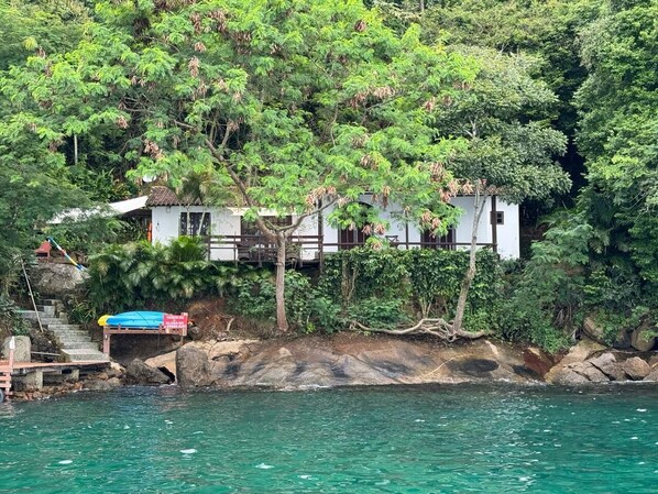 A house with a staircase leading to a dock, surrounded by lush greenery and a body of water. - Welcoming 3-bedroom house in Angra dos Reis for your getaway (Angra dos Reis)