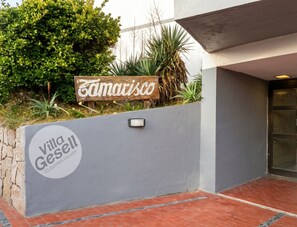 A villa named 'Villa Gesell' with a sign indicating 'Es Querer Volver' and a wooden sign above it.